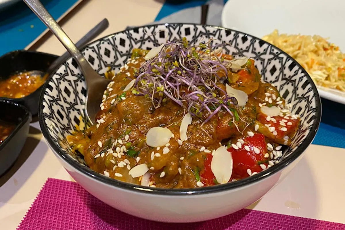 Plat de curri tradicional indi amb verdures i espècies, servit en bol de ceràmica a Reus