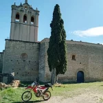 Moto Honda CRF250L frente a una iglesia románica en la Terra Alta